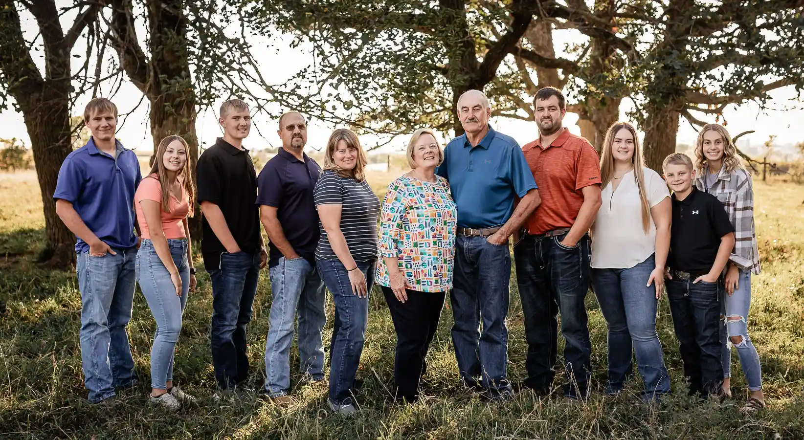 Three generations of the Carstens family stand outdoors, posed for a photo.